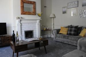 a living room with a couch and a fireplace at The Hampton Beautiful 3 Bedroom House with Conservatory & Garden in Scarborough