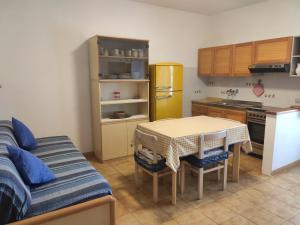 Appartamento Il Nespolo في بومونته: مطبخ مع طاولة وثلاجة صفراء