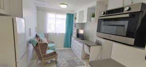 uma sala de estar com uma cozinha com um micro-ondas e uma televisão em Private Loadshedding free Flatlet, Fibre WiFi, Netflix, Security Deposit applies em Krugersdorp