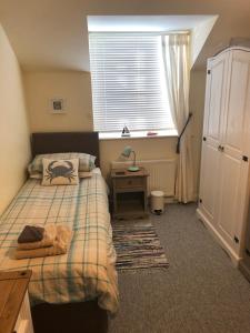 a bedroom with two beds and a desk and a window at Pixie Cottage in Eastbourne