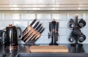 a kitchen counter with utensils hanging on a wall at Withnell Stays - Apartment One - Ground Floor - Retro Gaming Machine in Blackpool