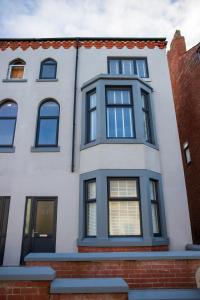 a white house with black windows at Withnell Stays - Apartment One - Ground Floor in Blackpool