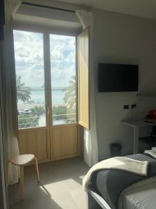 a bedroom with a large window with a view of the ocean at Drepanon, prospettive sul mediterraneo B&B in Trapani