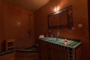 uma casa de banho com um lavatório e um espelho em Dar Labchara em Fez