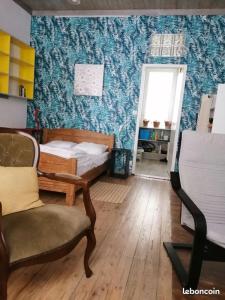 1 dormitorio con 1 cama, 1 silla y 1 puerta en Résidence Les Volets Bleus: Studio de 30 m² classé 2 *, en Rochefort