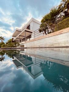 a building is reflected in a body of water at El jardin Botánico Villa LUZ in Altea