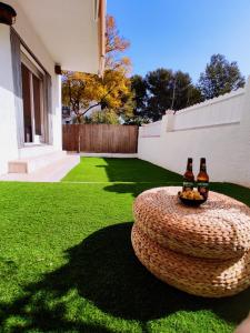 two bottles of beer on a circular table in a yard at Ca la Torreta in Torredembarra