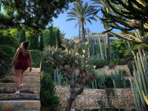 a woman walking up some stairs in a cactus garden at El jardin Botánico Villa LUZ in Altea