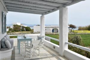 een patio met een tafel en stoelen en uitzicht op de oceaan bij Tonia Apartments Paros in Chrissi Akti