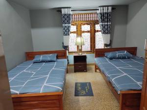 A bed or beds in a room at Singa Akham Guest Houses