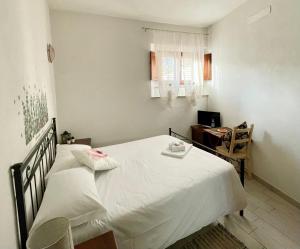 a bedroom with a large white bed and a desk at Affitta Camere Thomas' in Bagni di Lucca