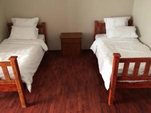 ウォルビスベイにあるCozy & spacious family homeのベッド2台&椅子2脚付