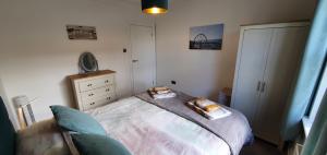 a small bedroom with a bed and a dresser at Tor View - Sorrento in Torquay