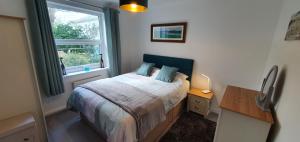 a small bedroom with a bed and a window at Tor View - Sorrento in Torquay