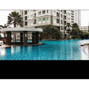 a large pool of blue water in front of a building at Thamrin Residences/2BR in Jakarta