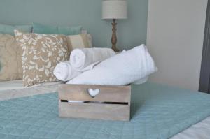 Una cama con toallas y una caja con un corazón. en TuttoTondo Roma, en Roma