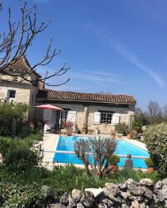 a house with a swimming pool in front of it at Pérard Chambres D’Hotes in Caylus