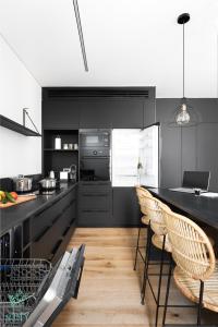 a kitchen with black cabinets and a table and chairs at CARMEL MARKET - Exclusive Collection - By HOMY in Tel Aviv