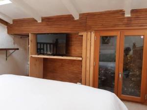 a bedroom with a wooden wall with a window at Garden Annexe 2 in Villeneuve-Loubet