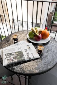 a table with a newspaper and a plate of fruit at CARMEL MARKET - Exclusive Collection - By HOMY in Tel Aviv