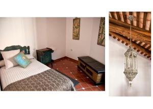een slaapkamer met een bed en een kroonluchter bij CR Casa Quinto in Constantina