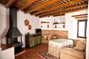 een woonkamer met een fornuis, een bank en een tafel bij CR Casa Quinto in Constantina