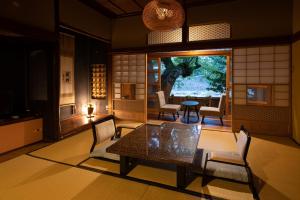 sala de estar con mesa, sillas y ventana en Okutsusou, en Kagamino