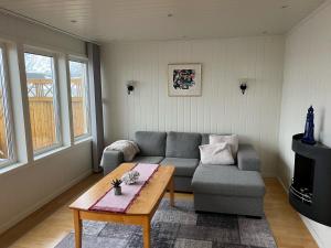 a living room with a couch and a coffee table at Vesterålen Kysthotell in Stokmarknes