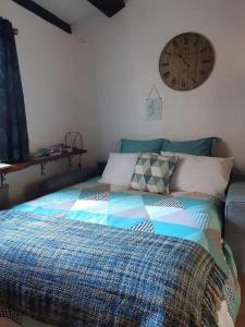 um quarto com uma cama com um relógio na parede em Garden Annexe em Villeneuve-Loubet