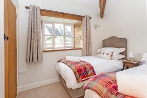 a bedroom with two beds and a window at 1 Homepiece in Chipping Campden