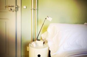 贝林佐拉Ca' Pölète, Do-Minus Design Retreat & SPA的床边床头柜上的一盏灯