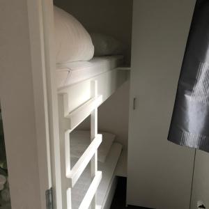 a closet with white shelves and a bed at Chalet Bosrand 42 Park Veluwshof 6 p in Hoenderloo +38 photos