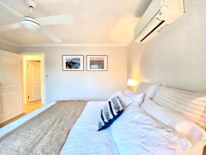una camera da letto con un letto grande con cuscini sopra di Rosebud Lovely House - Mornington Peninsula 3 BR holiday house - Jacuzzi - BBQ - Basketball ring - Beach - Hot springs a Rosebud