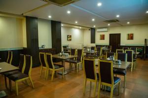 a restaurant with tables and chairs in a room at Arunaachalaa Resiidency in Chennai