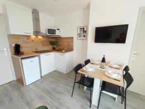 a kitchen and dining room with a table and chairs at Casa Flamingo - Appartement calme et moderne - 4 - in Canet-en-Roussillon +7 photos