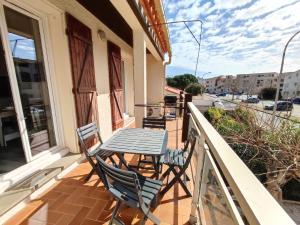 a table and chairs on the balcony of a house at Casa Flamingo - Appartement calme et moderne - 4 - in Canet-en-Roussillon