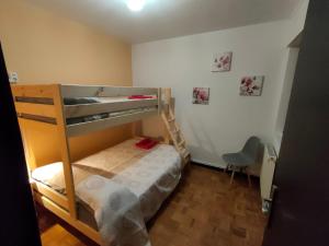 a bedroom with two bunk beds and a chair at CASA DANIELA Apartamentos in Estella