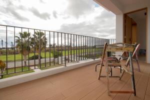a chair sitting on a balcony looking out at the ocean at mhouse44 in Peyia