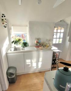 a white kitchen with a sink and a window at Idyllic Cornish Cottage, Superking bed, private garden dogs welcome in Truro