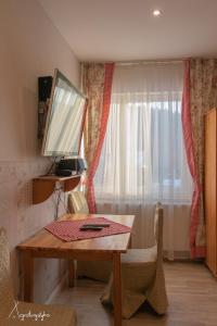 チュフフにあるAgroturystyka Nad Jeziorem-Osada Indiańskaの木製テーブルと窓が備わる客室です。