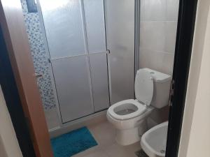 Un pequeño baño con inodoro y ducha. en Edificio La Vieja Casona, en Concepción del Uruguay