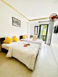 1 dormitorio con 2 camas con flores en Toro Homestay en Hoi An