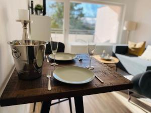 a wooden table with two plates and wine glasses at Bike Hike Ski Brilon - Ferienappartment in Brilon