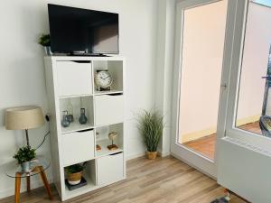 a white book shelf in a room with a tv at Bike Hike Ski Brilon - Ferienappartment in Brilon