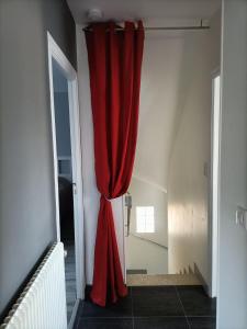 een rood gordijn aan de muur van een kamer bij Le gîte du Coche avec vue sur la Marne in Damery
