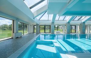 an indoor swimming pool with a glass ceiling at Luxury apartment Vodolei in Krapets
