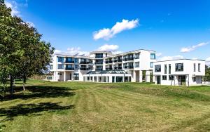 ein großes weißes Gebäude mit einem Feld davor in der Unterkunft Luxury apartment Vodolei in Krapets