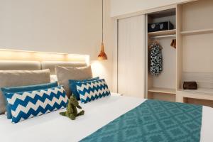 Un dormitorio con una cama con almohadas azules y blancas. en Playa Park Zensation, en Corralejo