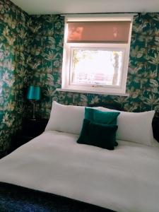 a bedroom with a white bed with a window at Garden Apartment Morpeth- with lockable bike storage! in Morpeth