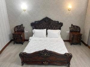 a bedroom with a large bed with two night stands at Hotel Astam in Kostanay